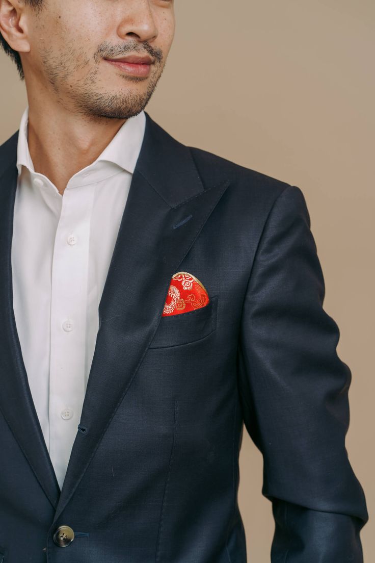 A brocade pocket square for a modern Vietnamese or Chinese wedding look. Made with a classic dragon brocade fabric so you can add that dash of red and gold to your tux. Can be custom made to match any of our cheongsam or ao dai wedding dresses. Stylist Notes: Matches nicely with any of our red and gold cheongsams or ao dais. Red Wedding Pocket Square, Elegant Red Pocket Square For Wedding, Elegant Red Wedding Pocket Square, Red Pocket Square For Wedding, Traditional Silk Suits For Formal Occasions, Wedding Groom Outfit, Asian Suit, Chinese Suit, Asian Suits