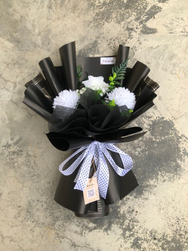 a bouquet of flowers is wrapped in black paper