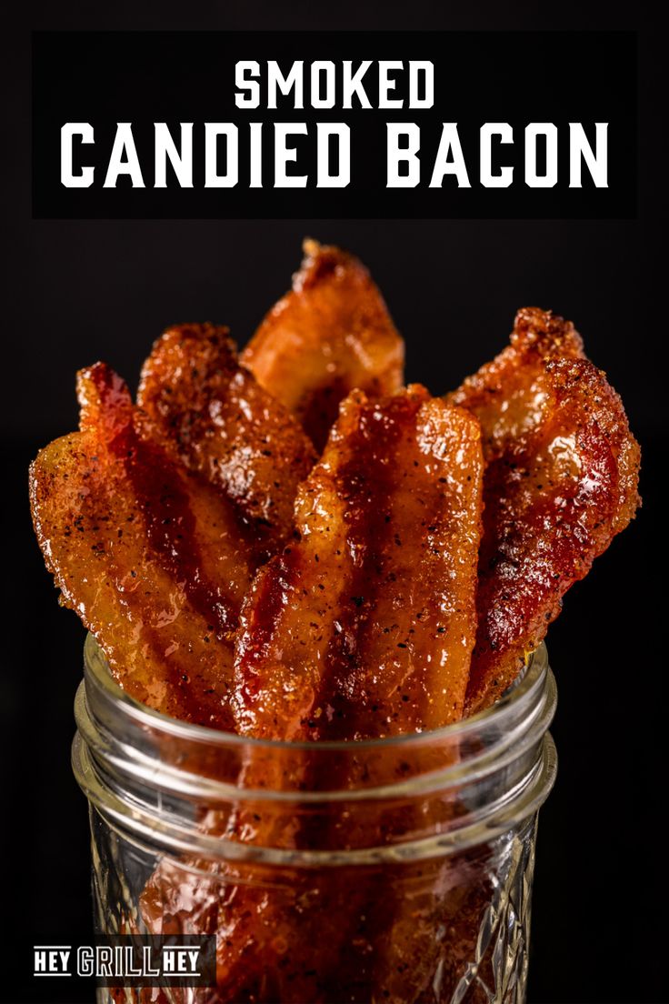 a jar filled with bacon sitting on top of a black table next to the words smoked candied bacon