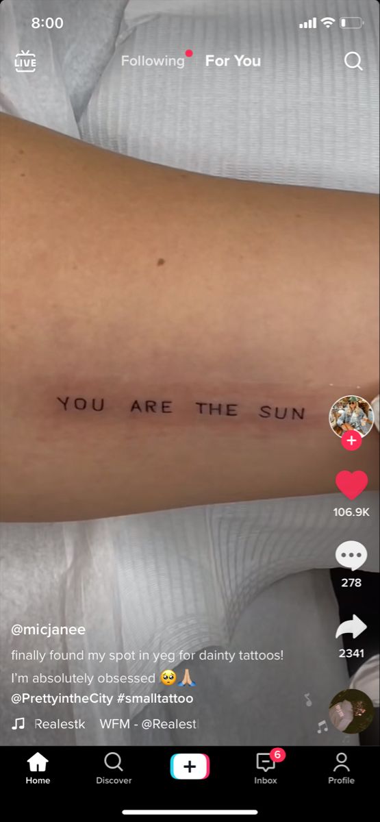 someone with a tattoo saying you are the sun