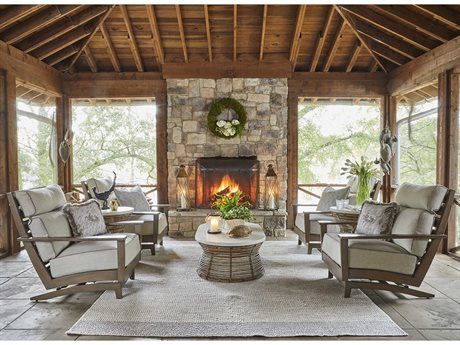 a living room filled with furniture and a fire place in front of a stone fireplace