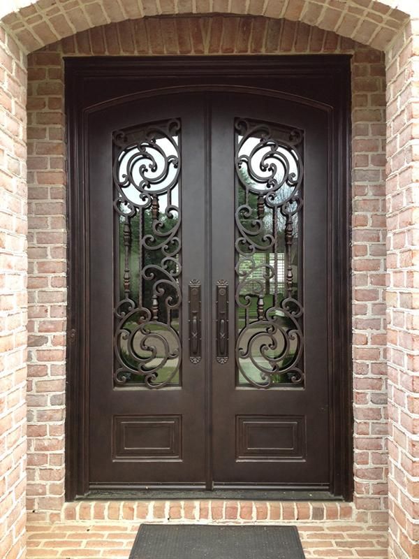 the front door to a house with wrought iron doors and glass panels on each side