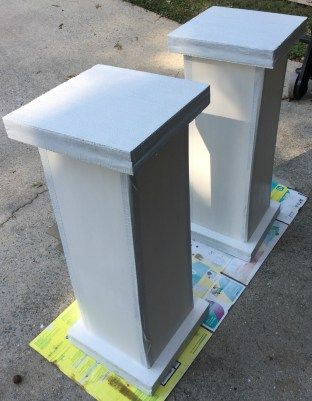 two white pedestals sitting on top of a piece of paper