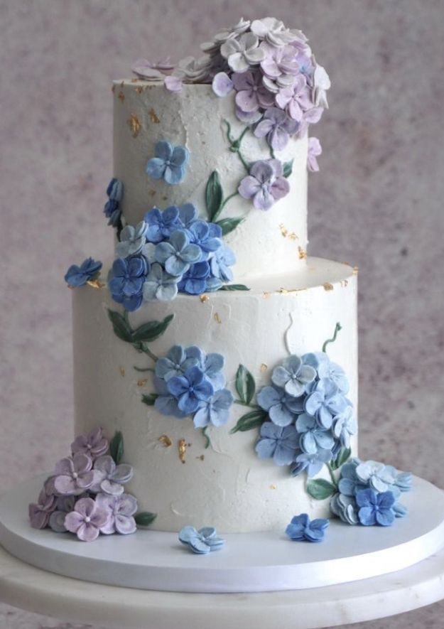 a three tiered cake with blue and purple flowers on it