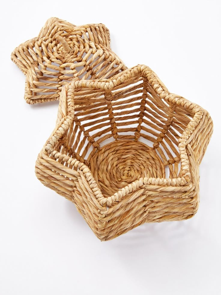 two wicker baskets sitting side by side on a white surface, one is empty