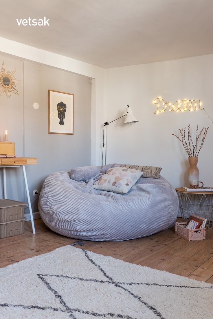 a large bean bag chair sitting on top of a wooden floor next to a table