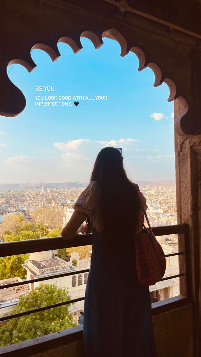 a woman looking out over the city from an ornate window with a quote on it