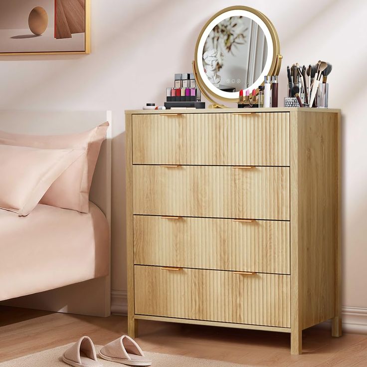 a bedroom with a bed, dresser and mirror on it's side table in front of a pink wall