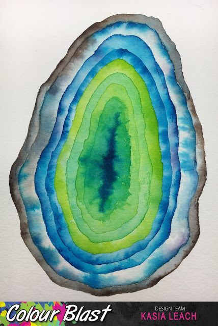 a piece of paper with watercolor paint on it that looks like a tree slice