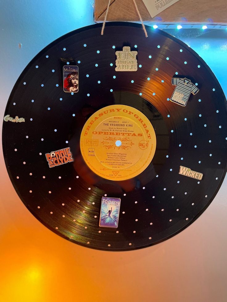 a record hanging from the ceiling with various stickers on it