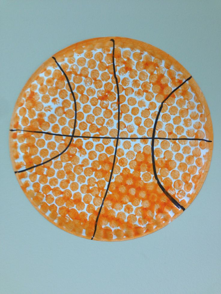 an orange and white plate with a basketball painted on the side, hanging from a wall