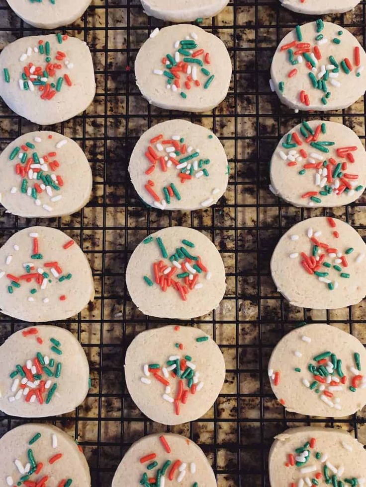 cookies with sprinkles and white frosting on a cooling rack