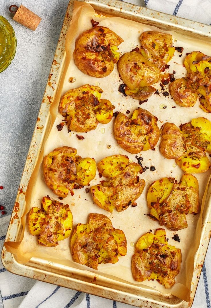 a baking pan filled with cooked potatoes on top of a blue and white table cloth