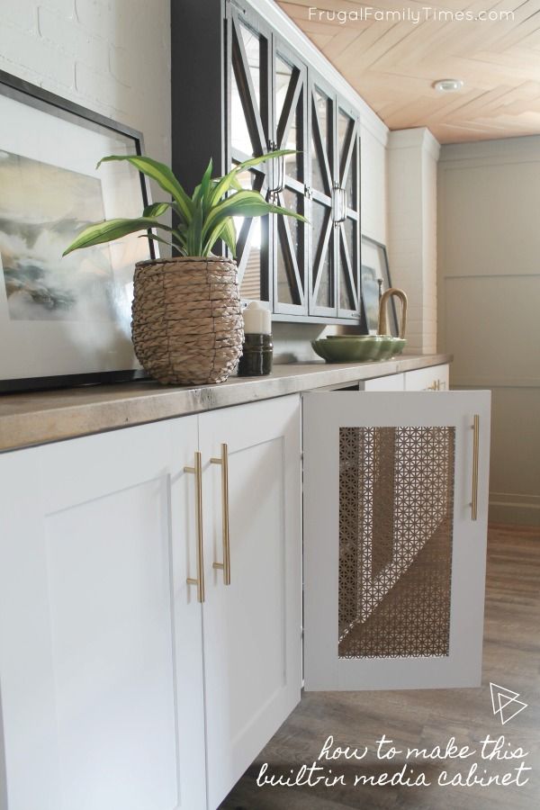 a kitchen with white cabinets and a potted plant on top of the cabinet doors