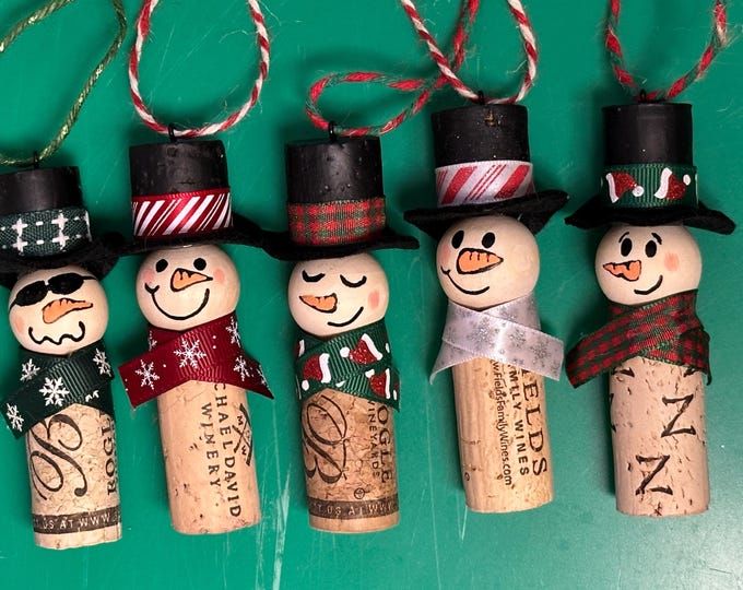 four wine cork snowmen with hats and scarfs