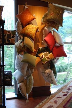 pillows are stacked on top of each other in front of a large window with an open door