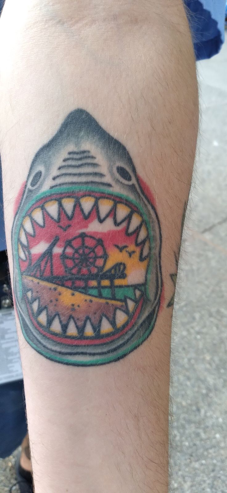 a man's arm with a shark tattoo on it, and an image of a fish