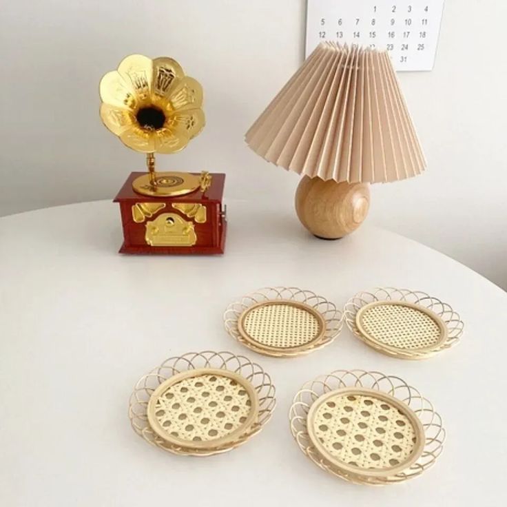 four gold plated dishes and a lamp on a table