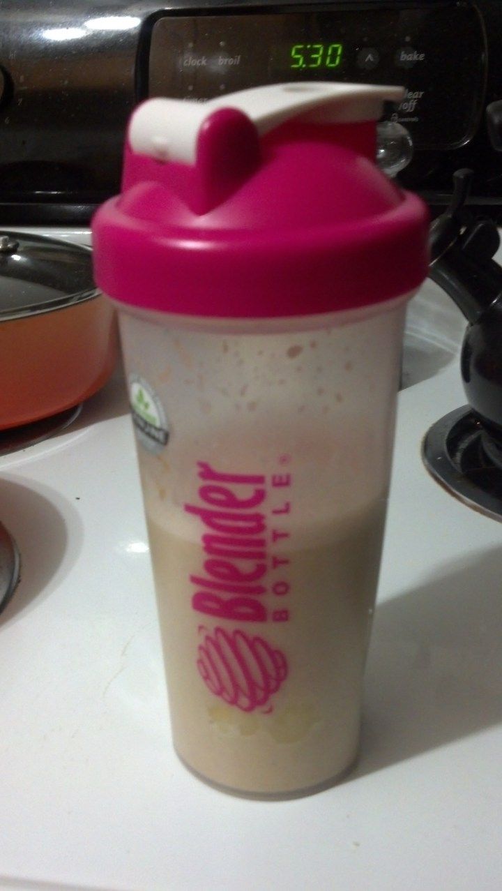 a pink and white shaker cup sitting on top of a counter next to an oven