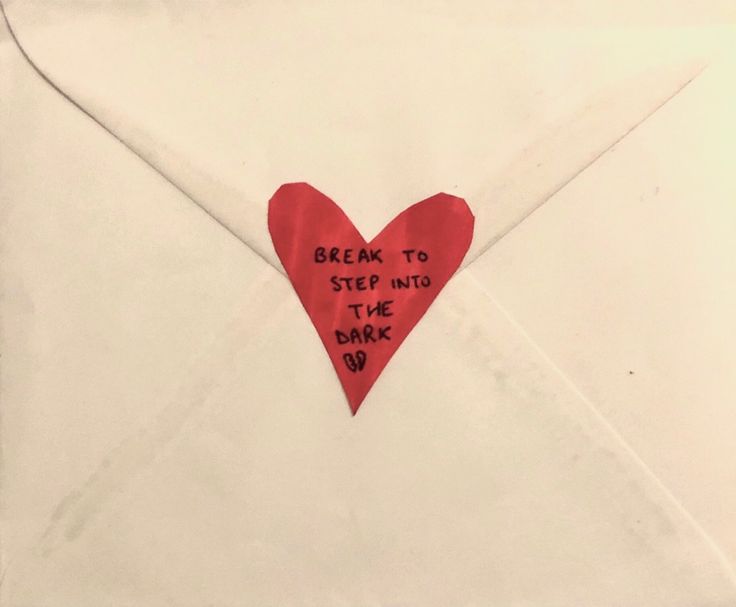 a white envelope with a red heart on it and the words dream to step into the dark