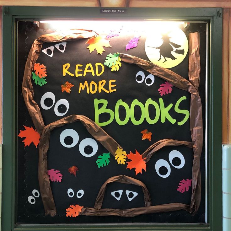 a bulletin board that reads read more books and decorated with fake leaves, googly eyes and bats