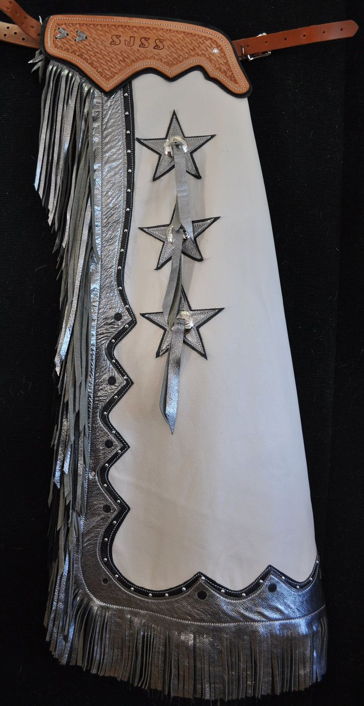 a white skirt with silver fringes and stars on the side, hanging from a leather belt