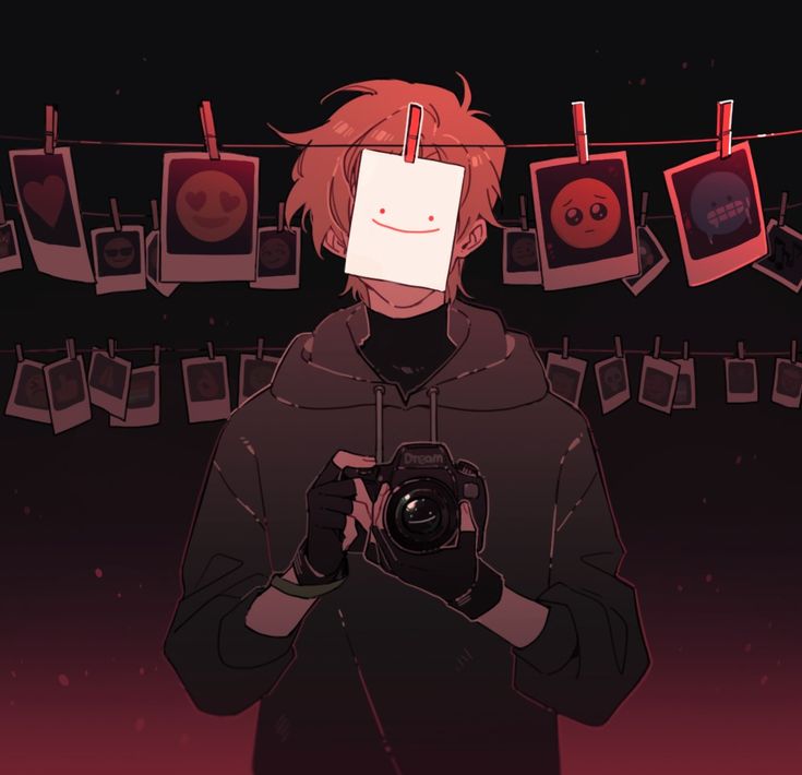 a person holding a camera in front of a bunch of pictures hanging on a line