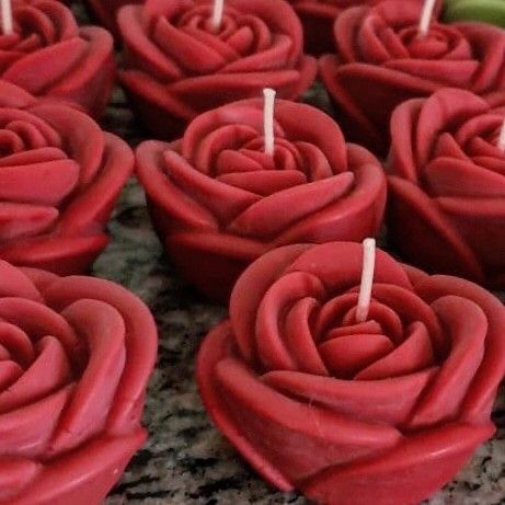 many red cupcakes with candles in the shape of roses