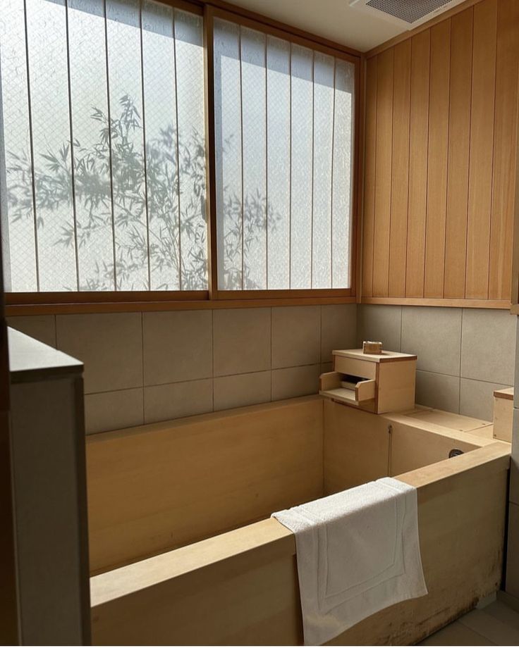 an empty bathroom with wood paneling and windows