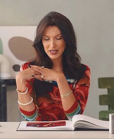 a woman sitting at a table with an open book in front of her and looking down