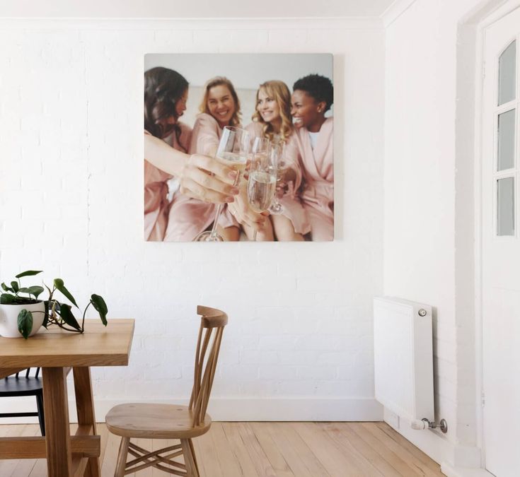 a group of women toasting with champagne in front of a photo on the wall