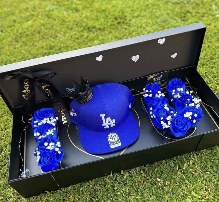 the los angeles dodgers baseball hat and gloves are in a gift box with blue roses