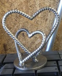 two heart shaped metal objects sitting on top of a keyboard