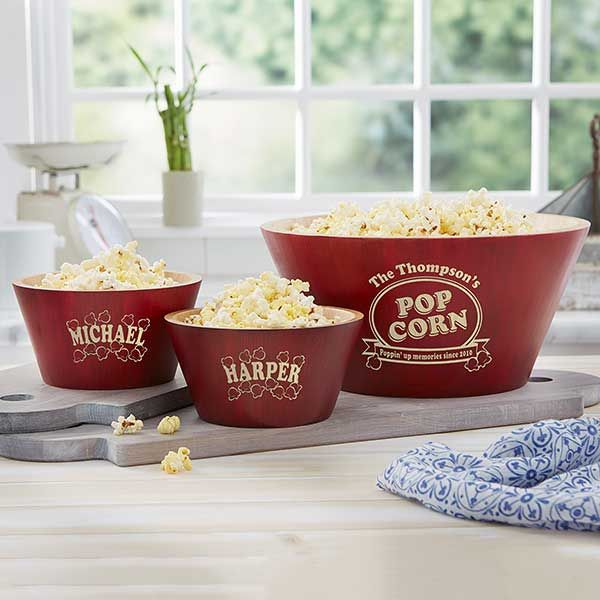 three red bowls filled with popcorn sitting on top of a counter