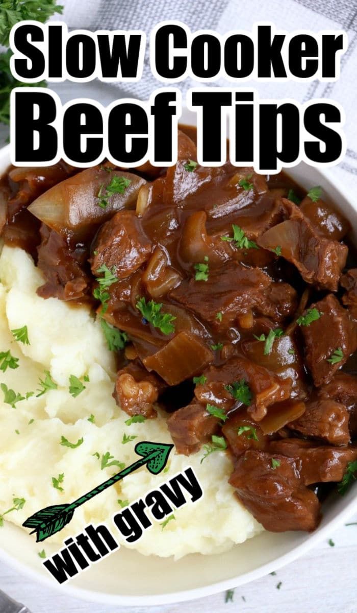 slow cooker beef tips with gravy in a bowl on top of mashed potatoes