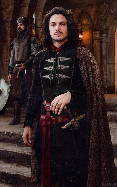 a man dressed in medieval clothing standing next to another man