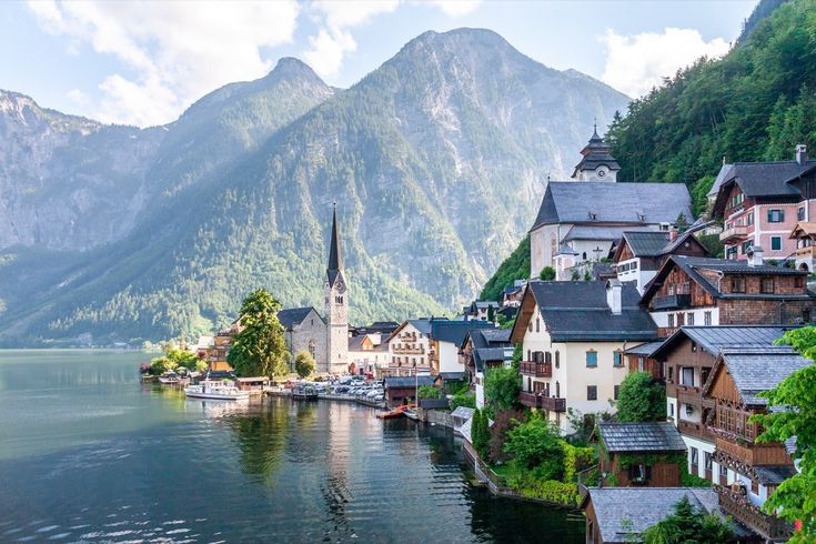 a town on the edge of a lake with mountains in the background