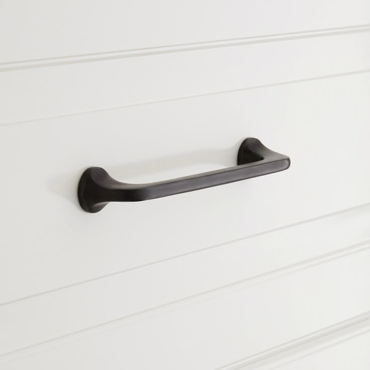 a black handle on a white cabinet door