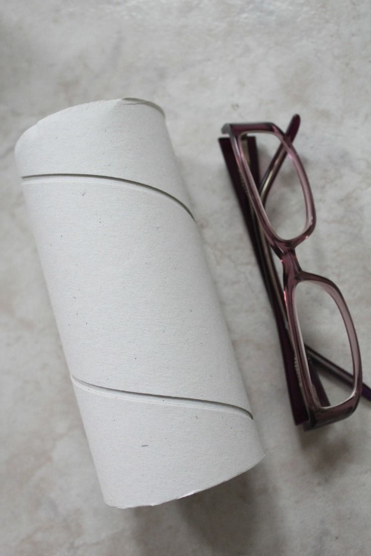 a roll of toilet paper next to some glasses on the floor in front of it