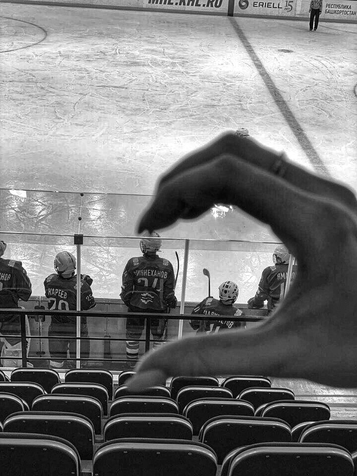 a hand is pointing at an ice hockey game in front of the goalie's