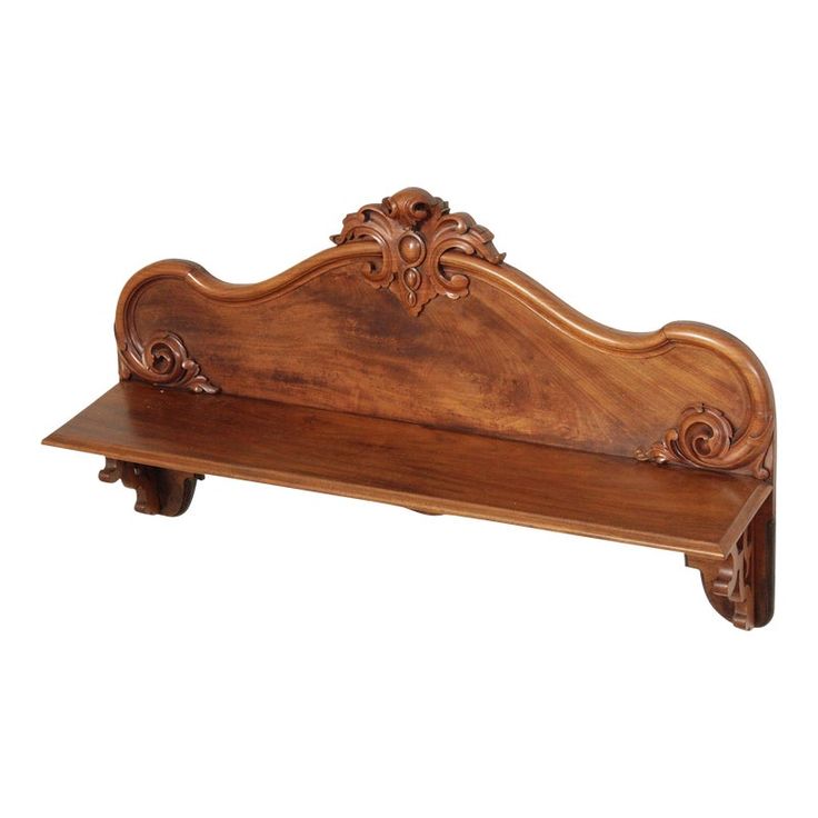 a wooden bench with carvings on the top and bottom, sitting against a white background