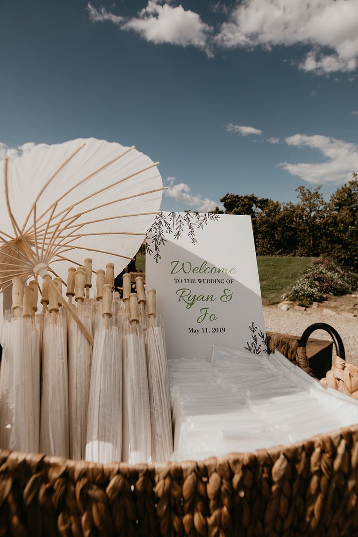 an umbrella and some bottles in a basket on the ground with other items around it