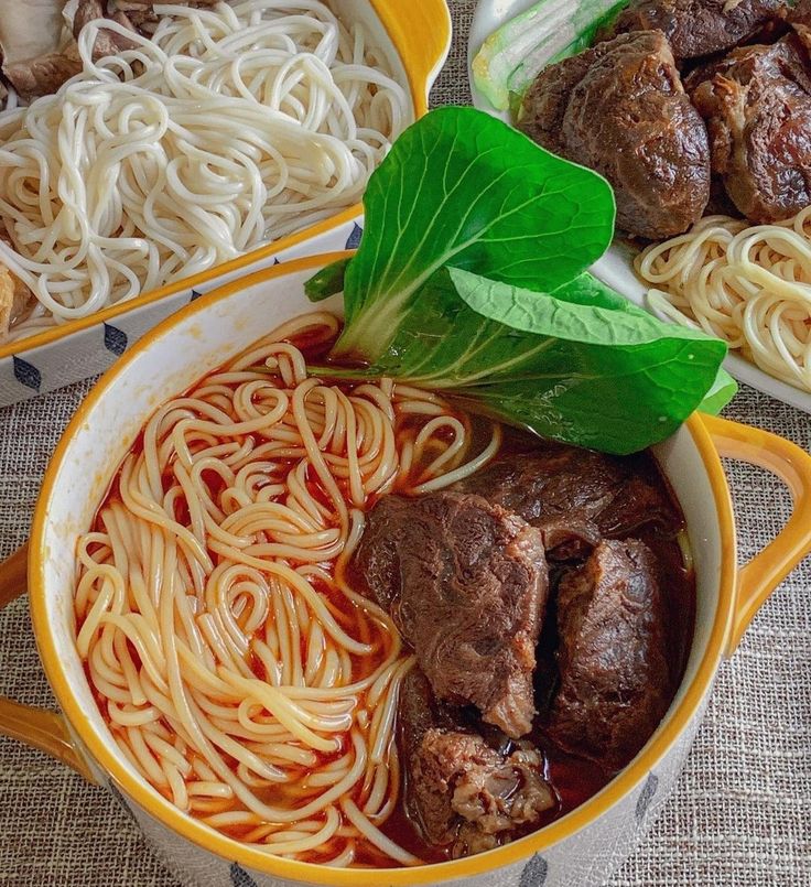 there are many different types of food in the bowl on the table, including meat and noodles