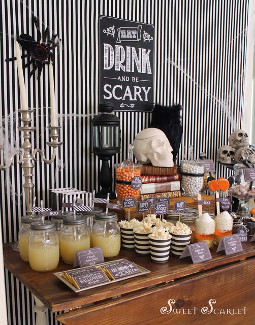 a table topped with lots of halloween treats and desserts next to a sign that says drink and be scary