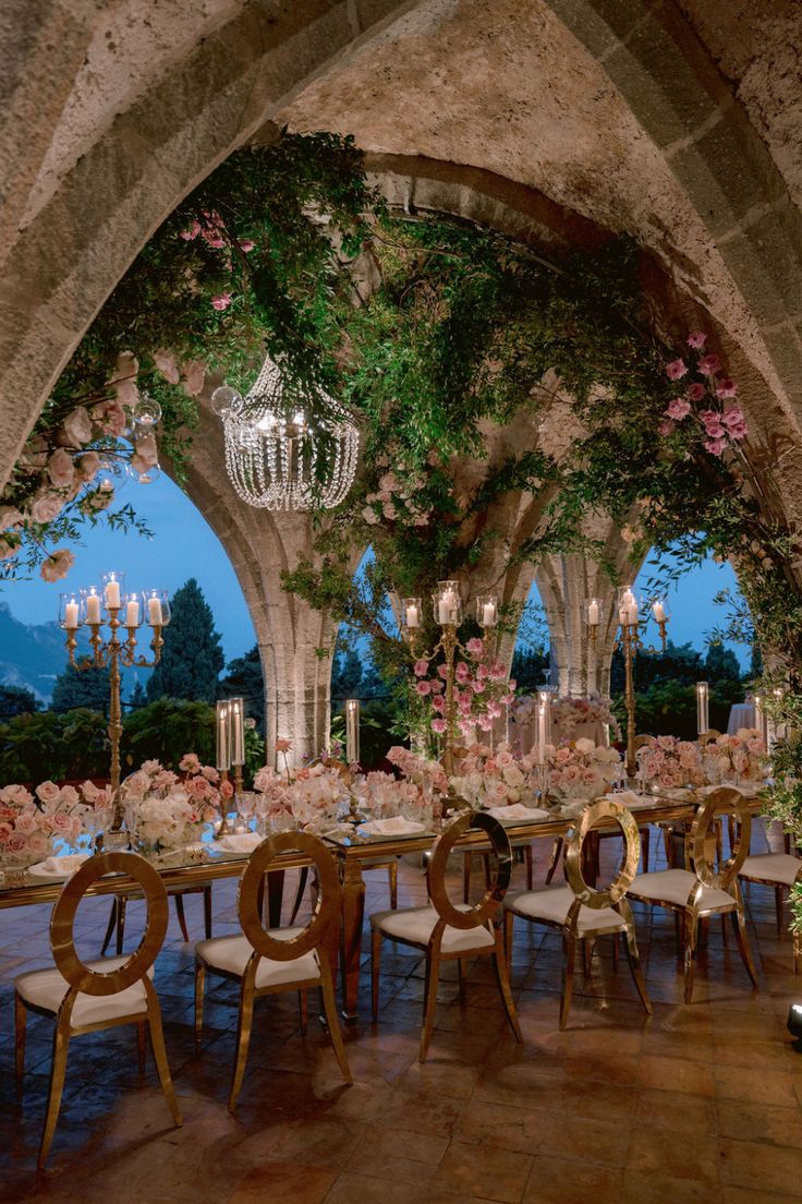 an outdoor dining area with chandeliers and tables set up for a formal function