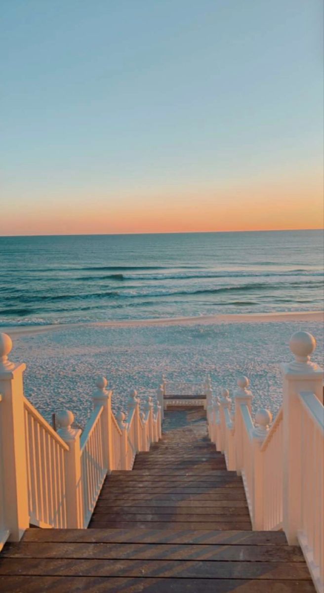 the stairs lead down to the beach at sunset