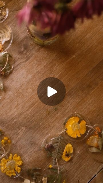 flowers are arranged in baskets on a table with wine glasses and other items around it