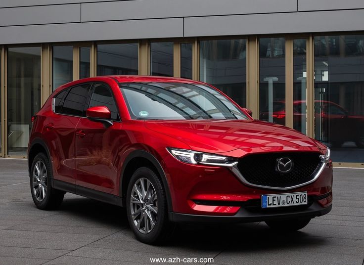 a red mazda cx - 5 parked in front of a building