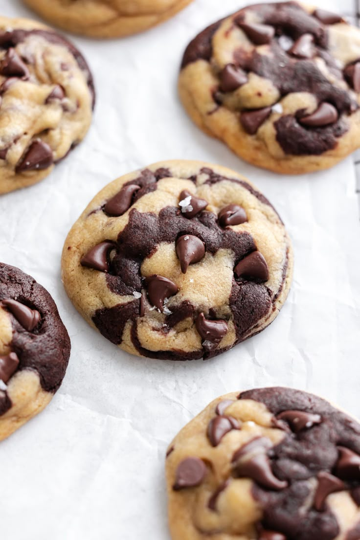 chocolate chip cookies are lined up on a baking sheet