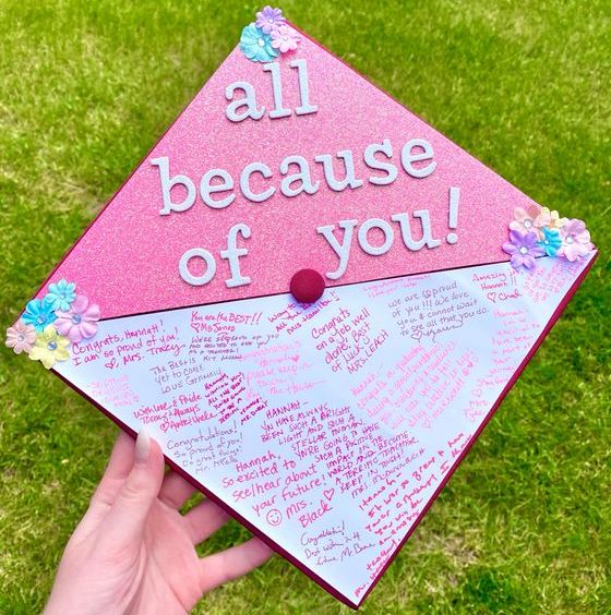 someone holding up a pink graduation cap with writing on it that says, all because of you